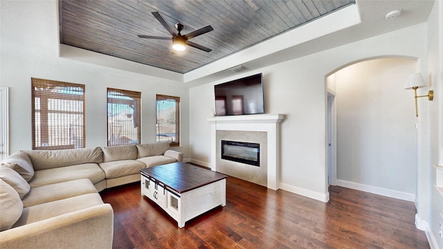 living room with wooden ceiling, dark hardwood / wood-style flooring, ceiling fan, and a raised ceiling