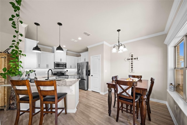 kitchen featuring white cabinets, kitchen peninsula, a breakfast bar, stainless steel appliances, and light stone counters