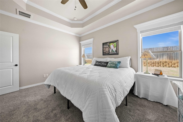 bedroom with crown molding, carpet, a tray ceiling, and ceiling fan