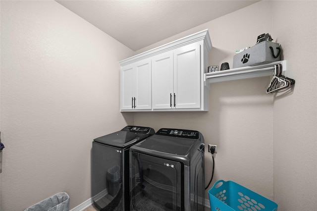 washroom with washing machine and dryer and cabinets