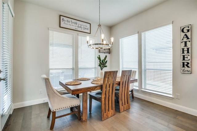 dining area featuring hardwood / wood-style floors, a healthy amount of sunlight, and a chandelier