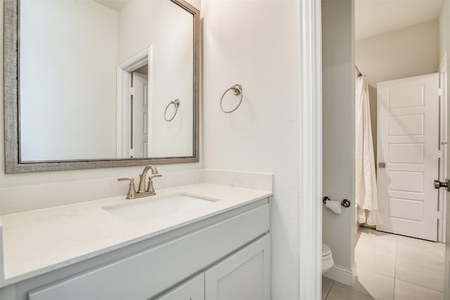 bathroom featuring toilet, vanity, and tile patterned flooring