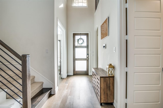 foyer featuring light hardwood / wood-style floors and a towering ceiling