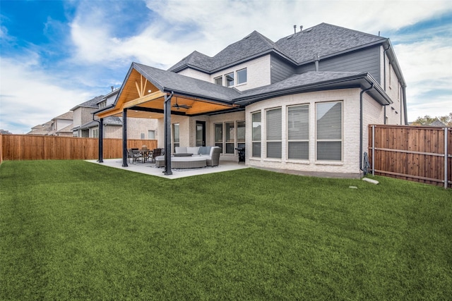 rear view of property featuring ceiling fan, a patio, an outdoor hangout area, and a yard