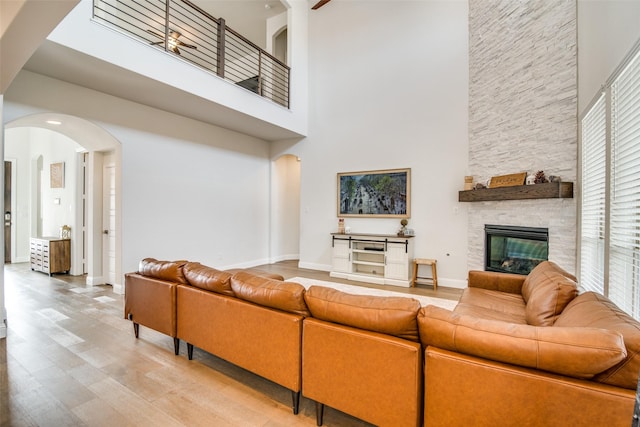 living room with a high ceiling, wood-type flooring, and a fireplace