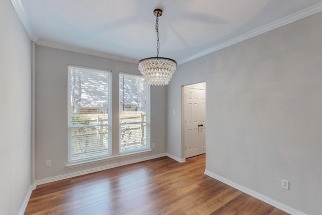 unfurnished dining area featuring crown molding, light hardwood / wood-style floors, and an inviting chandelier