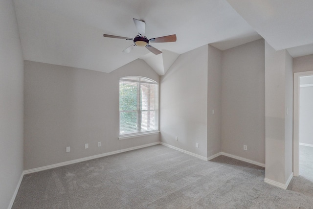 unfurnished room featuring ceiling fan, light colored carpet, and lofted ceiling