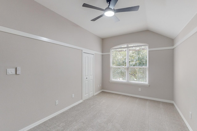 spare room featuring ceiling fan, light colored carpet, and lofted ceiling