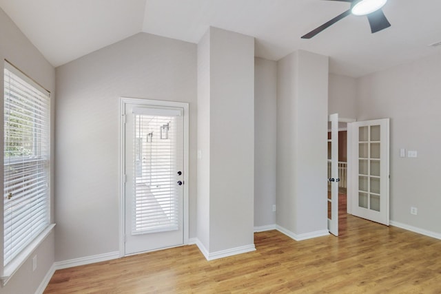 empty room with ceiling fan, light hardwood / wood-style floors, and lofted ceiling