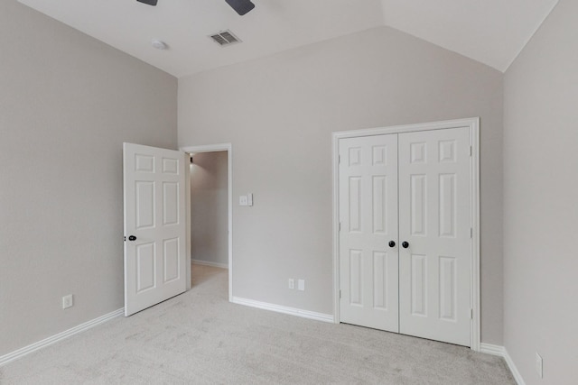 unfurnished bedroom with a closet, ceiling fan, light colored carpet, and lofted ceiling