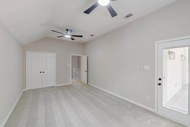 unfurnished bedroom featuring light carpet, vaulted ceiling, and ceiling fan