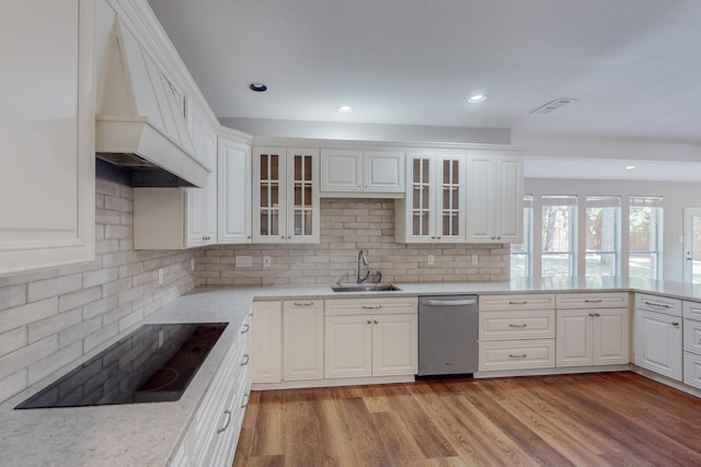 kitchen featuring stainless steel dishwasher, black electric stovetop, white cabinets, and custom range hood