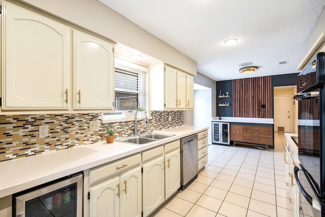 kitchen with sink, light tile patterned floors, beverage cooler, and dishwasher