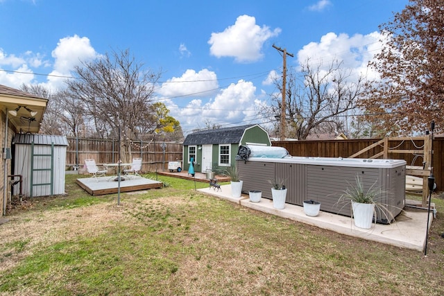 view of yard with a wooden deck, a storage unit, and a hot tub