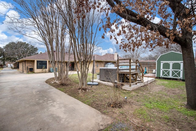 view of yard with a storage shed and a hot tub