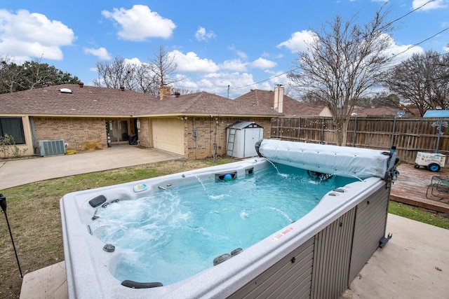 view of pool featuring a hot tub and central air condition unit