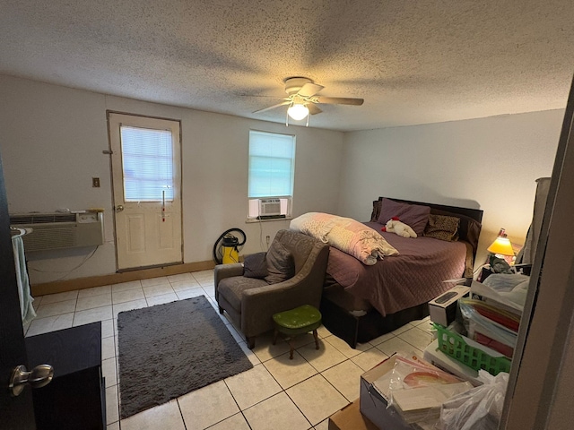 bedroom with ceiling fan, a textured ceiling, a wall mounted air conditioner, and light tile patterned flooring