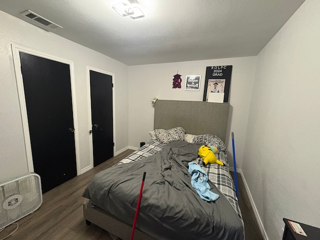 bedroom with dark wood-type flooring