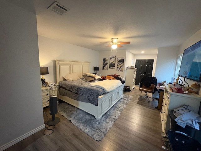 bedroom with hardwood / wood-style floors, a closet, and ceiling fan