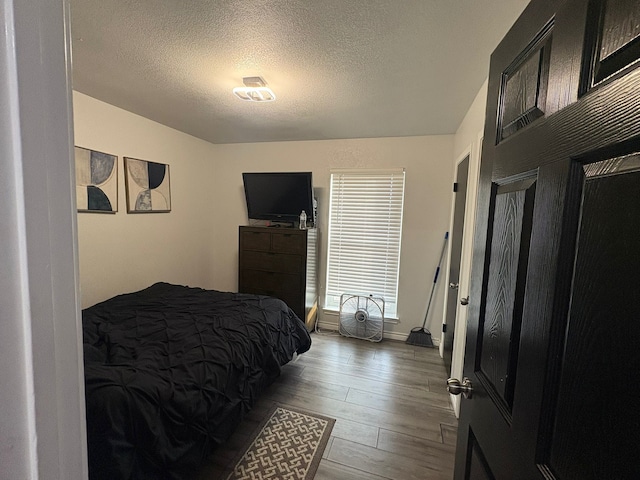 bedroom featuring hardwood / wood-style floors and a textured ceiling