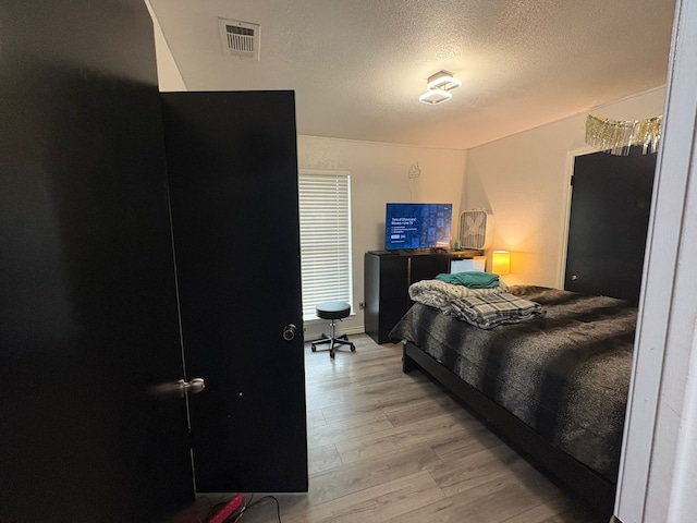 bedroom featuring hardwood / wood-style floors and a textured ceiling