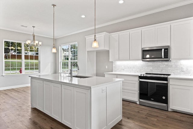 kitchen with decorative light fixtures, sink, white cabinets, stainless steel appliances, and a center island with sink