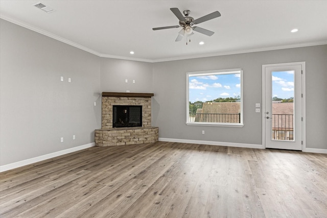 unfurnished living room with crown molding, ceiling fan, a fireplace, and light wood-type flooring