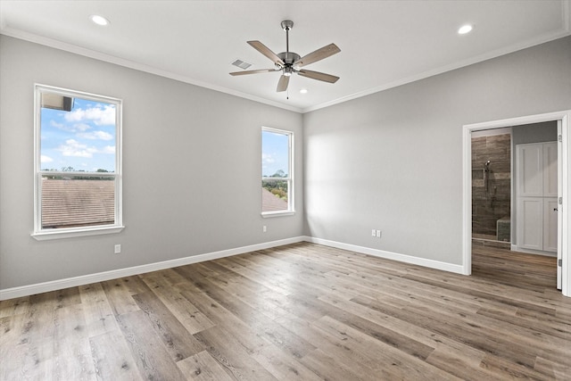 empty room with ceiling fan, ornamental molding, and light hardwood / wood-style floors