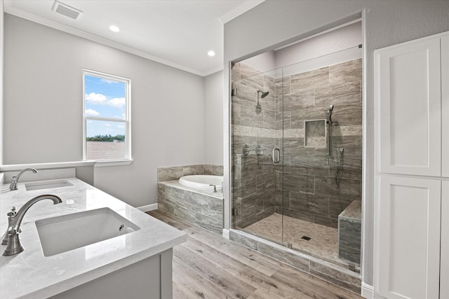 bathroom featuring crown molding, vanity, plus walk in shower, and wood-type flooring