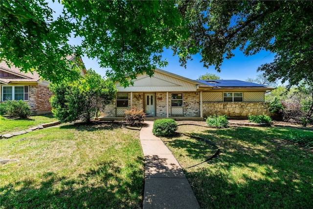 single story home featuring a front lawn and solar panels