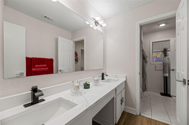 bathroom featuring vanity, hardwood / wood-style flooring, and a textured ceiling