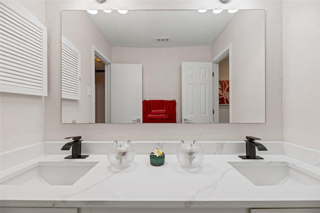 bathroom with vanity and a textured ceiling