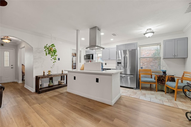 kitchen with gray cabinetry, appliances with stainless steel finishes, ornamental molding, island exhaust hood, and light hardwood / wood-style floors