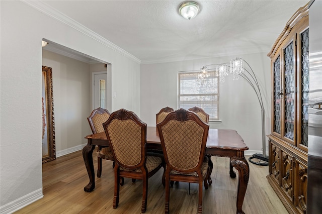 dining area featuring crown molding and light hardwood / wood-style floors