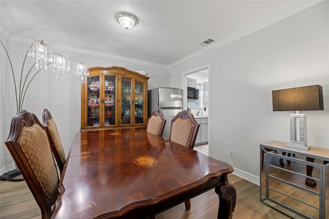 dining room featuring hardwood / wood-style floors and crown molding