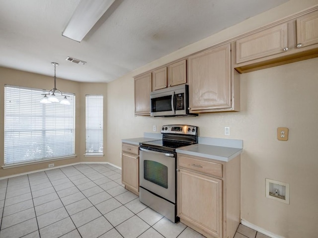 kitchen featuring pendant lighting, light brown cabinets, stainless steel appliances, and light tile patterned flooring