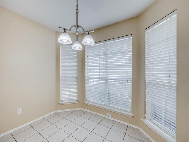 unfurnished dining area with light tile patterned floors and an inviting chandelier