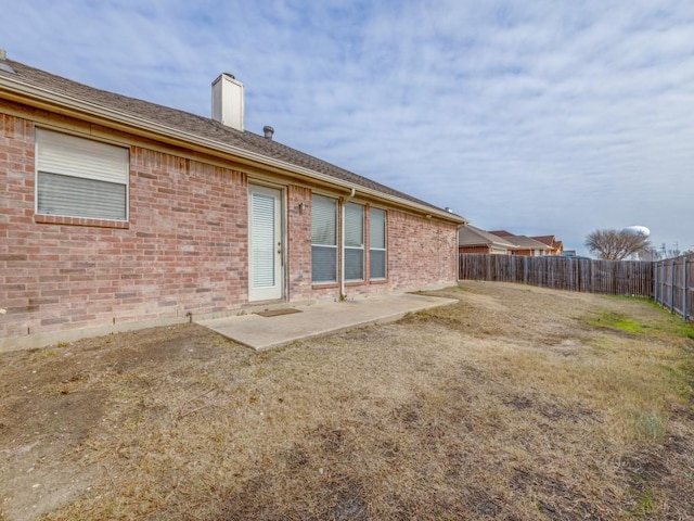 back of house with a lawn and a patio