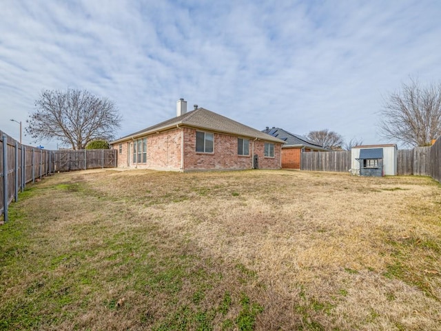 back of property featuring a lawn and a storage unit