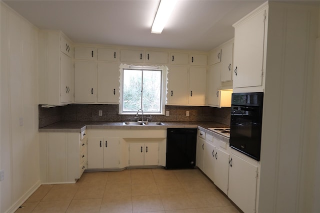 kitchen featuring tasteful backsplash, sink, white cabinets, light tile patterned floors, and black appliances