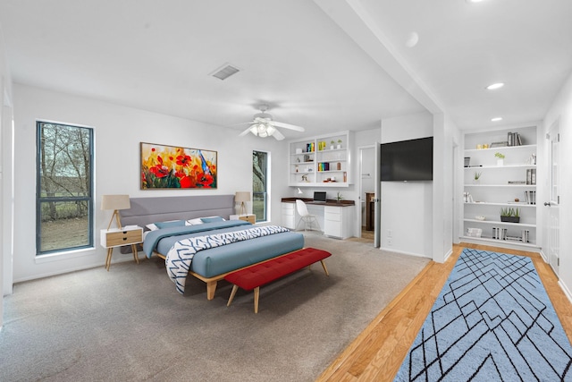 carpeted bedroom featuring multiple windows and ceiling fan