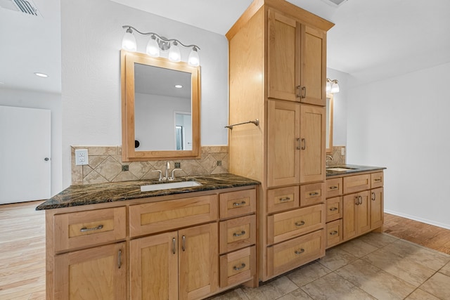 bathroom featuring vanity, backsplash, and wood-type flooring