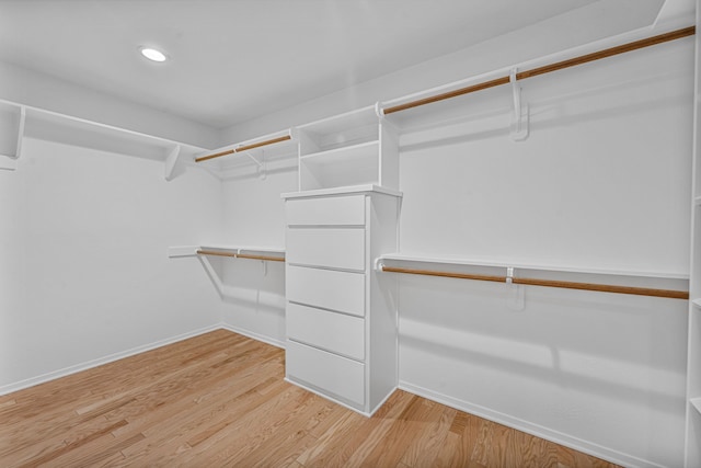 walk in closet with light hardwood / wood-style flooring