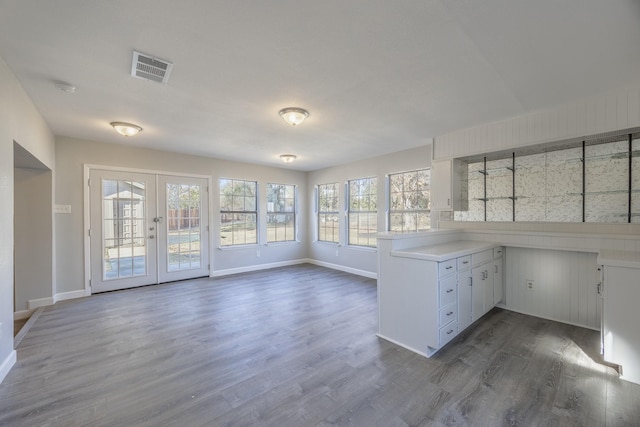 kitchen featuring white cabinets, french doors, kitchen peninsula, and dark hardwood / wood-style flooring