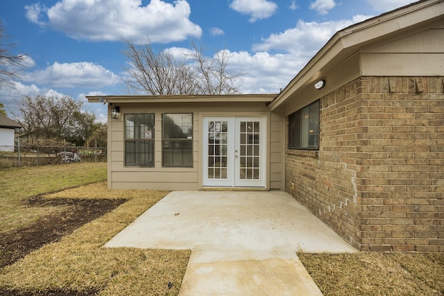 property entrance with a patio, a yard, and french doors