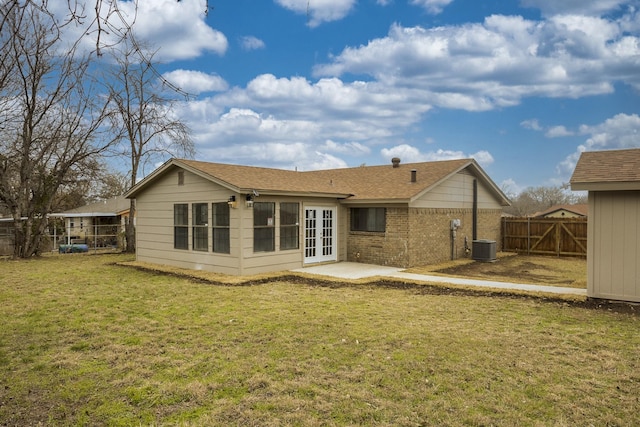 rear view of house with french doors, a lawn, and central AC