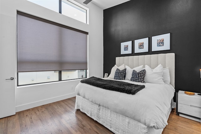 bedroom with hardwood / wood-style floors and multiple windows