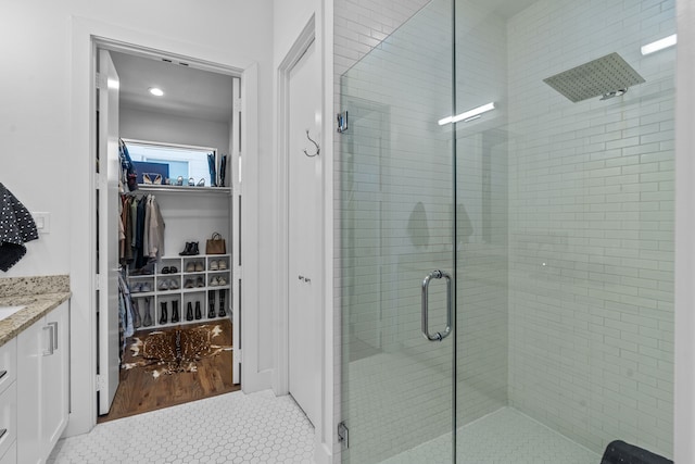 bathroom with an enclosed shower, vanity, and tile patterned flooring