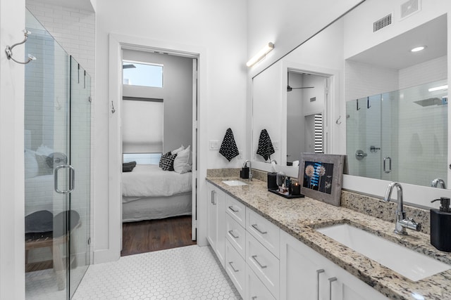 bathroom with tile patterned floors, walk in shower, and vanity