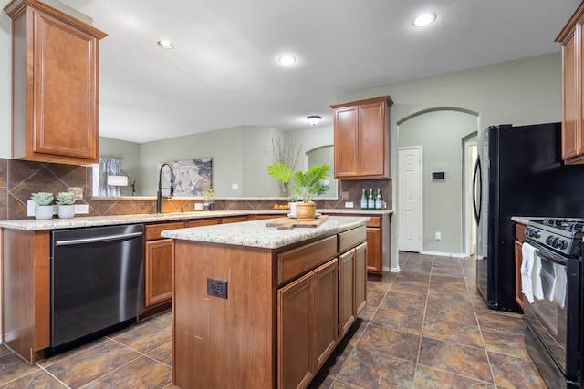 kitchen featuring dishwasher, sink, a kitchen island, black gas range, and kitchen peninsula